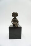 FIGURA Z BRĄZU SIEDZĄCY CHŁOPCZYK NA PODSTAWIE Z KAMIENIA