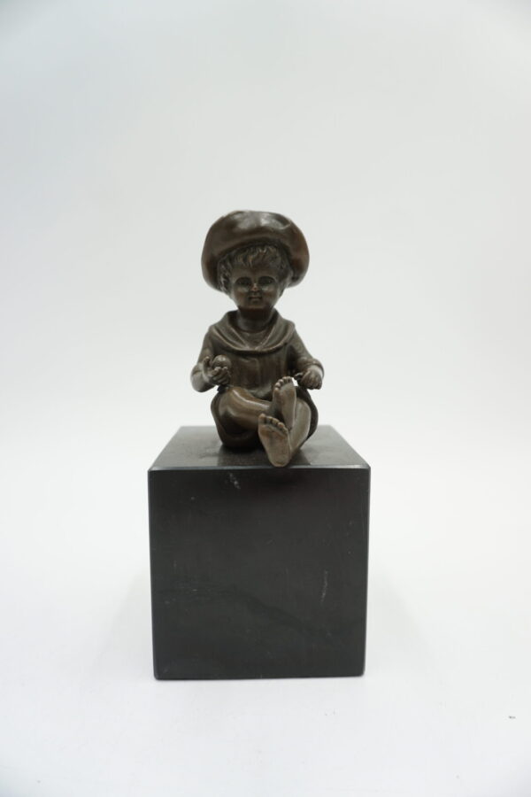 FIGURA Z BRĄZU SIEDZĄCY CHŁOPCZYK NA PODSTAWIE Z KAMIENIA