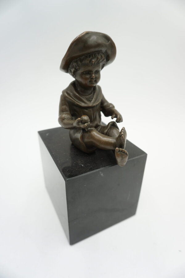 FIGURA Z BRĄZU SIEDZĄCY CHŁOPCZYK NA PODSTAWIE Z KAMIENIA