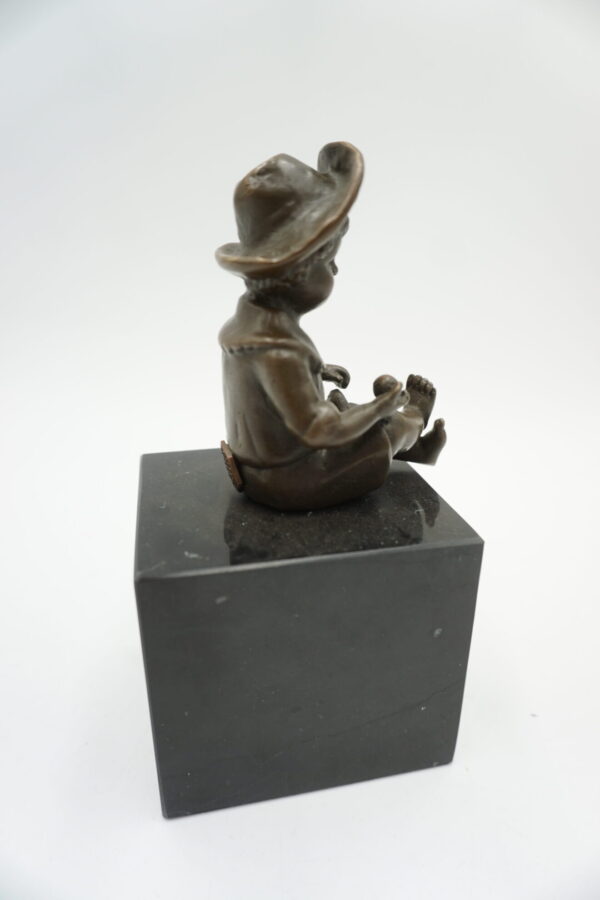 FIGURA Z BRĄZU SIEDZĄCY CHŁOPCZYK NA PODSTAWIE Z KAMIENIA